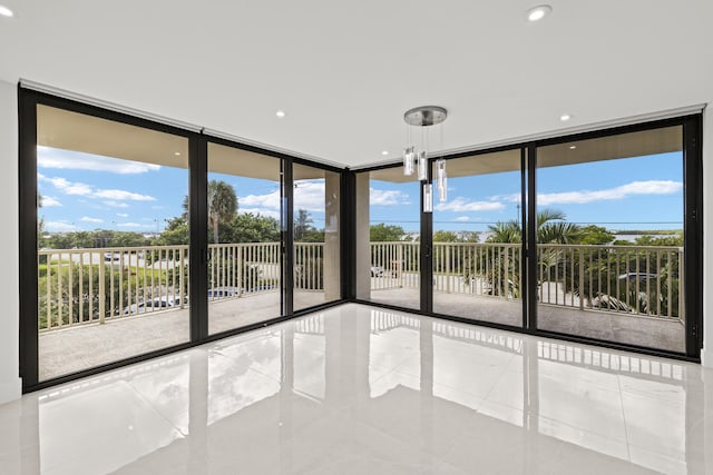 empty room featuring tile patterned floors, plenty of natural light, and a wall of windows