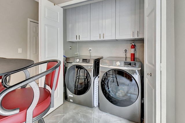 washroom with washer and clothes dryer and cabinets