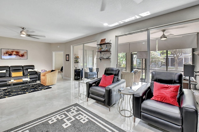 living room featuring ceiling fan and a textured ceiling