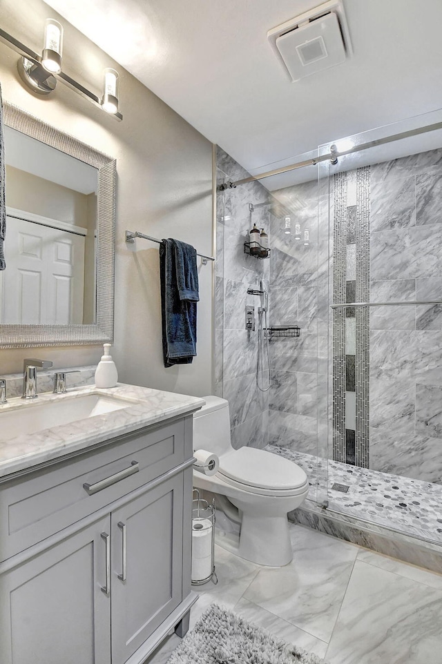 bathroom featuring vanity, toilet, and a shower with shower door