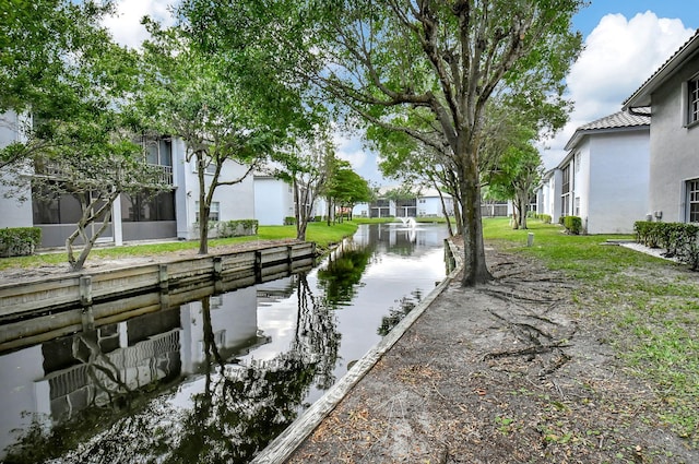 dock area featuring a water view and a lawn