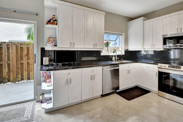 kitchen with white cabinets, appliances with stainless steel finishes, backsplash, and sink