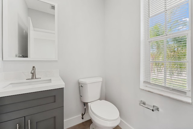 bathroom with vanity, a healthy amount of sunlight, and toilet