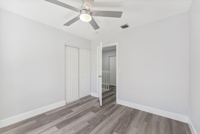 unfurnished bedroom with a closet, light hardwood / wood-style floors, and ceiling fan