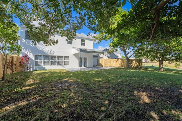 rear view of house featuring a patio and a lawn