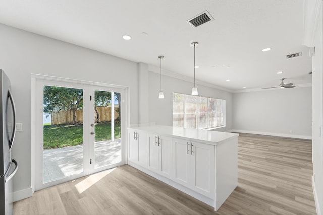 kitchen with kitchen peninsula, ceiling fan, white cabinets, and light wood-type flooring