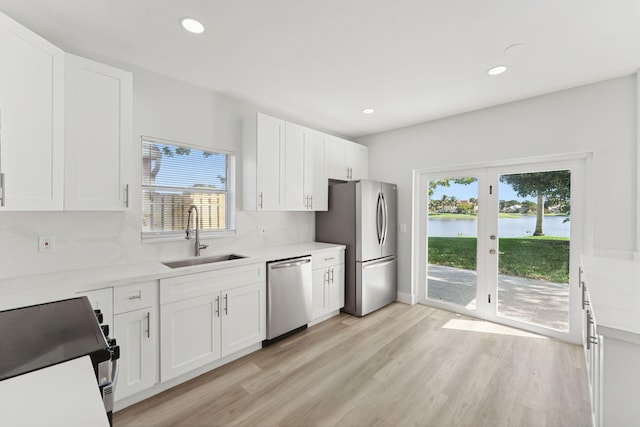 kitchen with sink, stainless steel appliances, a healthy amount of sunlight, and a water view