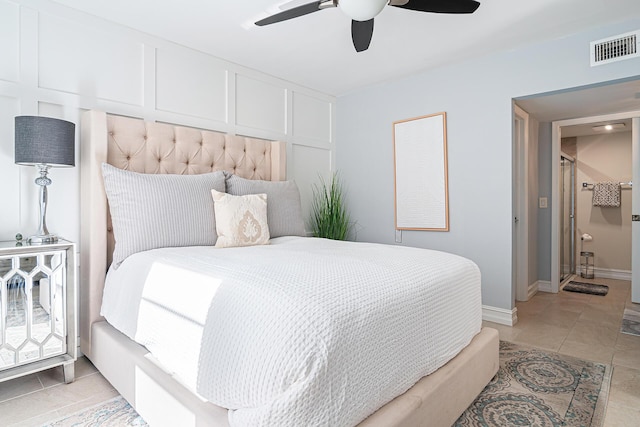 tiled bedroom with ceiling fan and ensuite bath