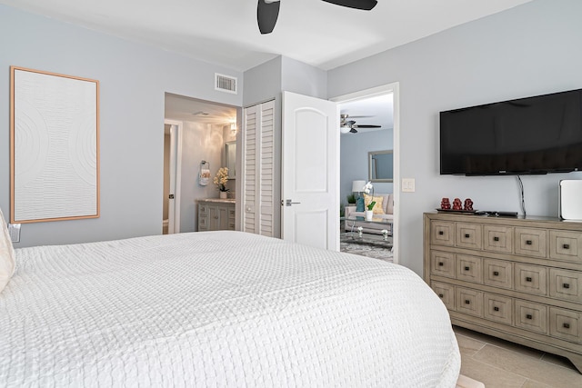 tiled bedroom with ceiling fan and ensuite bath