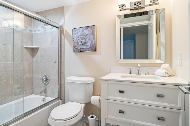 full bathroom featuring vanity, bath / shower combo with glass door, and toilet