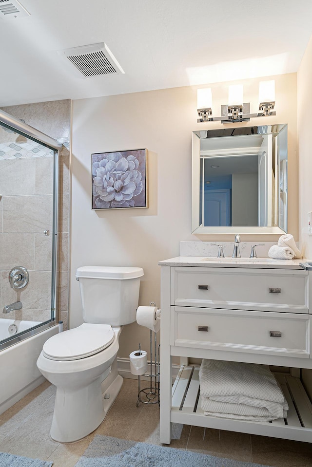 full bathroom featuring tile patterned floors, vanity, toilet, and enclosed tub / shower combo