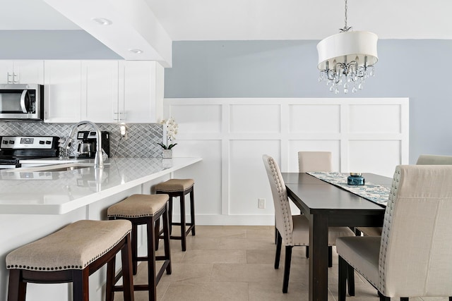 tiled dining area with a chandelier and sink