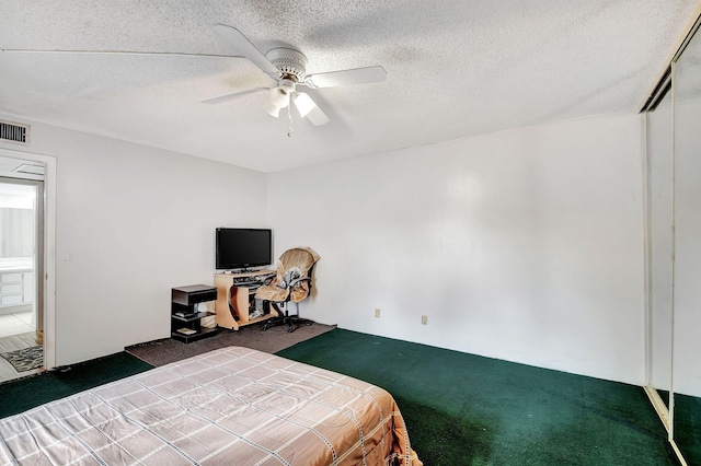 carpeted bedroom featuring ceiling fan, a closet, and a textured ceiling