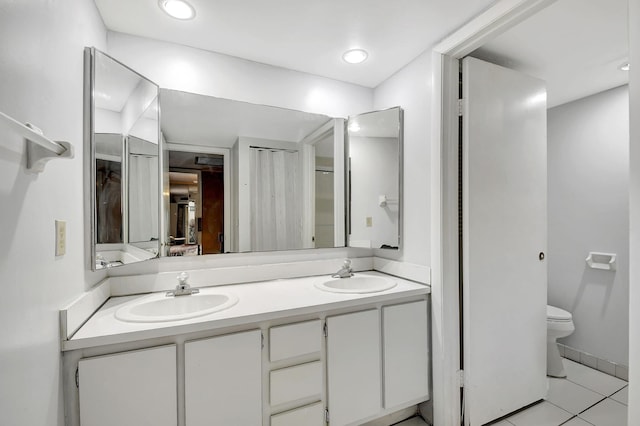 bathroom with tile patterned flooring, vanity, and toilet