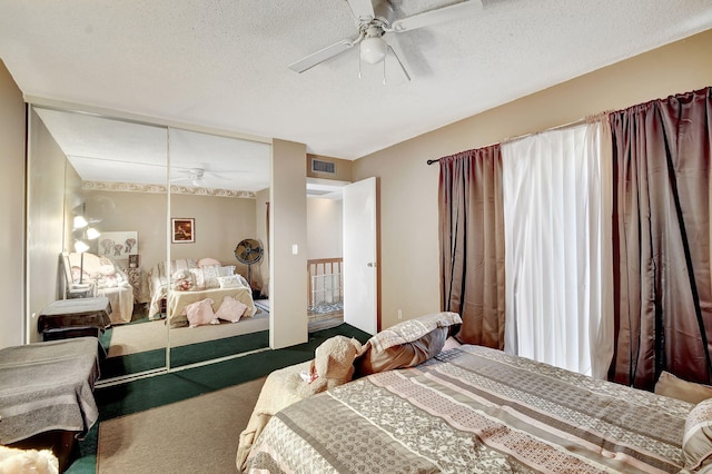 bedroom featuring a textured ceiling, carpet floors, a closet, and ceiling fan