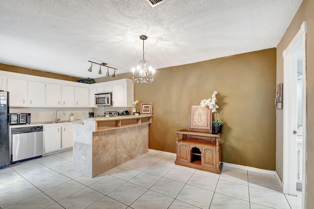 kitchen featuring kitchen peninsula, a textured ceiling, black appliances, pendant lighting, and white cabinets