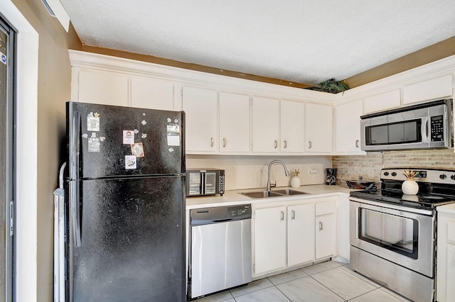 kitchen with white cabinetry, sink, tasteful backsplash, light tile patterned floors, and black appliances