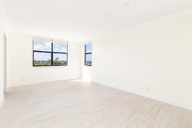 empty room with light hardwood / wood-style flooring and ornamental molding