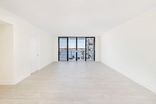 unfurnished room with ornamental molding and a wall of windows