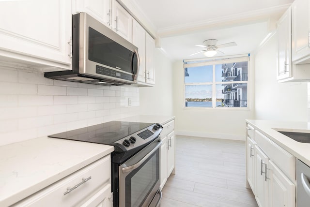 kitchen with white cabinetry, ceiling fan, crown molding, decorative backsplash, and appliances with stainless steel finishes