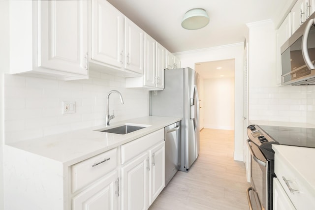 kitchen with backsplash, sink, light hardwood / wood-style floors, white cabinetry, and stainless steel appliances