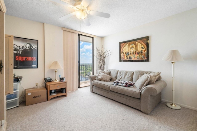 living room featuring ceiling fan, carpet, and a textured ceiling