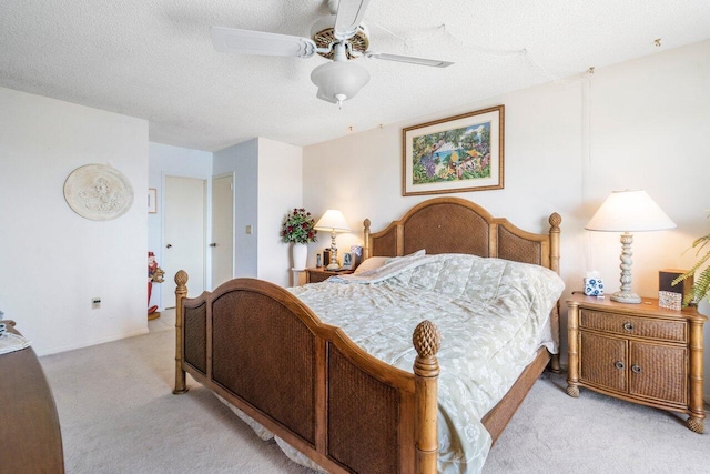 carpeted bedroom featuring ceiling fan and a textured ceiling