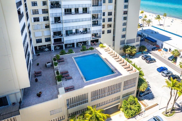 view of swimming pool featuring a water view and a beach view