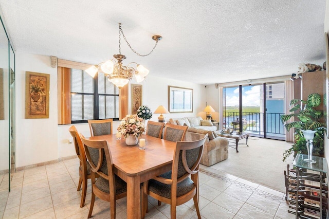 dining area featuring light tile patterned floors, a textured ceiling, and an inviting chandelier