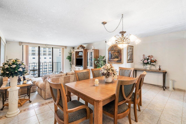 dining area with floor to ceiling windows, light tile patterned flooring, a textured ceiling, and a chandelier