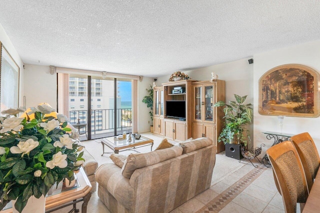 tiled living room with expansive windows and a textured ceiling