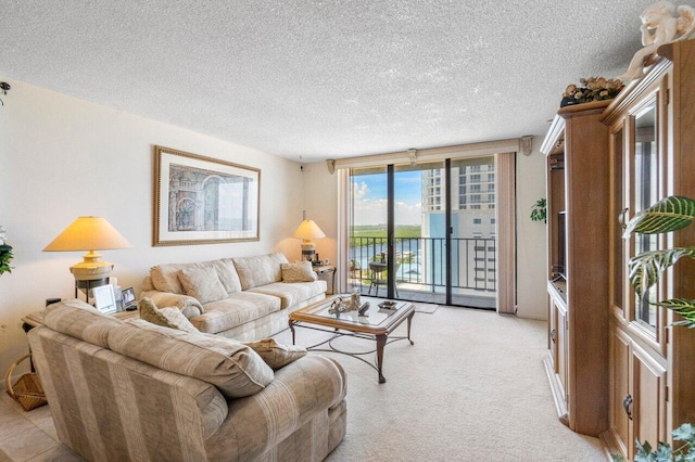 carpeted living room with a textured ceiling, a water view, and expansive windows