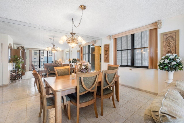 tiled dining space with a notable chandelier and a textured ceiling