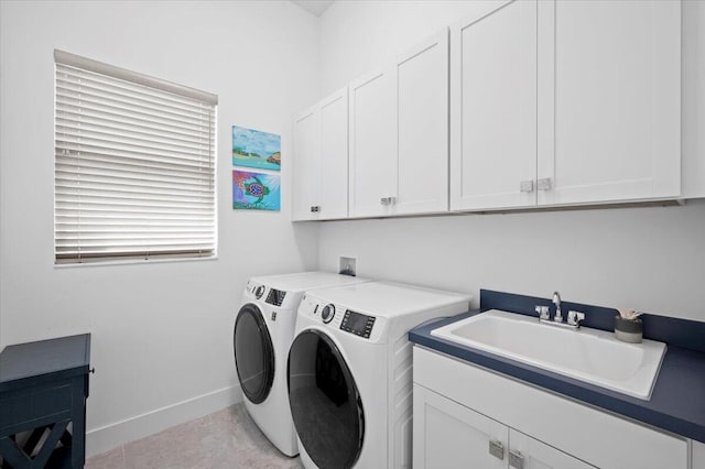 washroom featuring washing machine and dryer, sink, light tile patterned floors, and cabinets