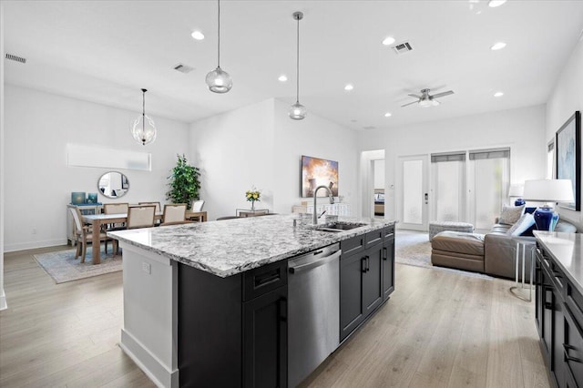 kitchen with dishwasher, a center island with sink, sink, ceiling fan, and decorative light fixtures