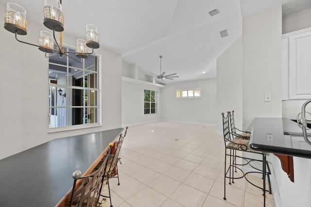 dining area featuring vaulted ceiling, ceiling fan, and light tile patterned flooring