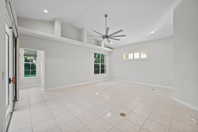 spare room featuring ceiling fan, plenty of natural light, light tile patterned floors, and lofted ceiling