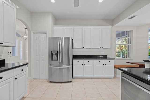 kitchen with white cabinetry, stainless steel fridge, light tile patterned floors, and an inviting chandelier