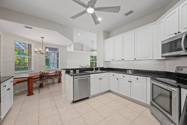 kitchen featuring kitchen peninsula, light tile patterned flooring, white cabinetry, and stainless steel appliances