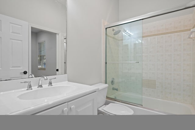 full bathroom with shower / bath combination with glass door, vanity, and toilet