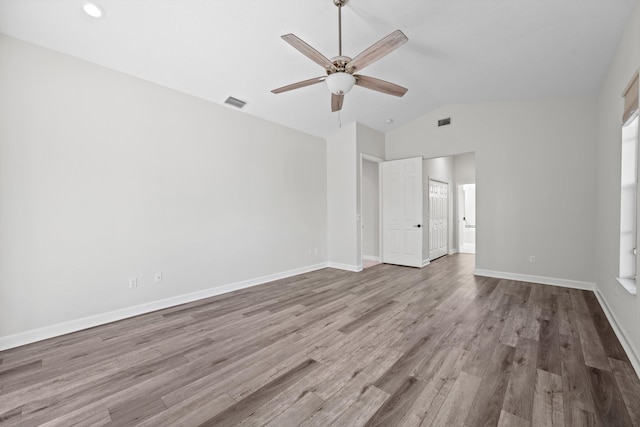 empty room featuring hardwood / wood-style flooring, vaulted ceiling, and ceiling fan