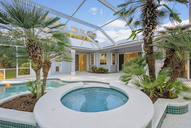 view of swimming pool with ceiling fan, a lanai, an in ground hot tub, and a patio