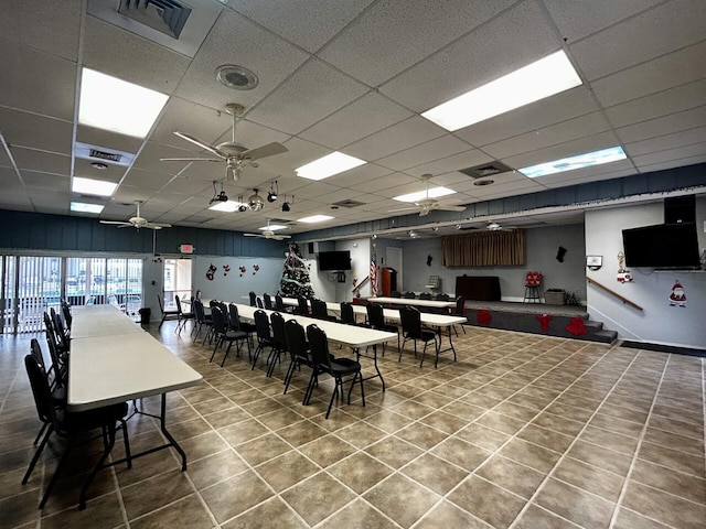 dining space featuring ceiling fan and a drop ceiling