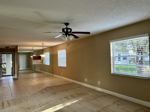 unfurnished bedroom featuring ceiling fan, a textured ceiling, and a closet