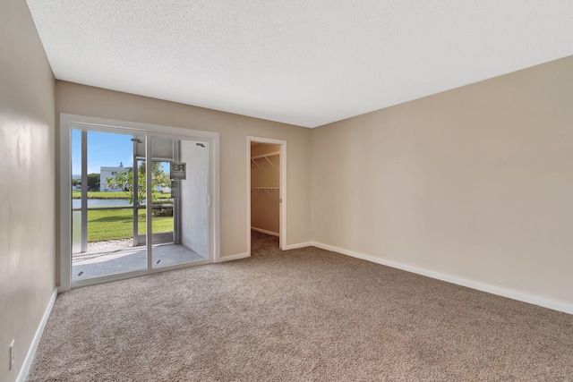 carpeted spare room featuring a textured ceiling