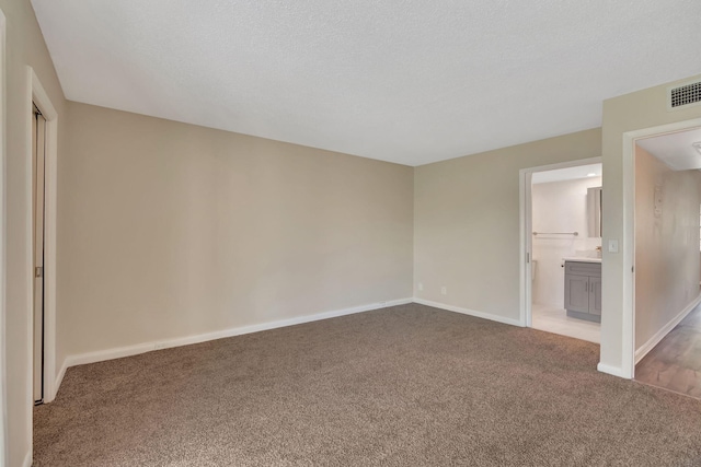 interior space featuring light carpet and a textured ceiling