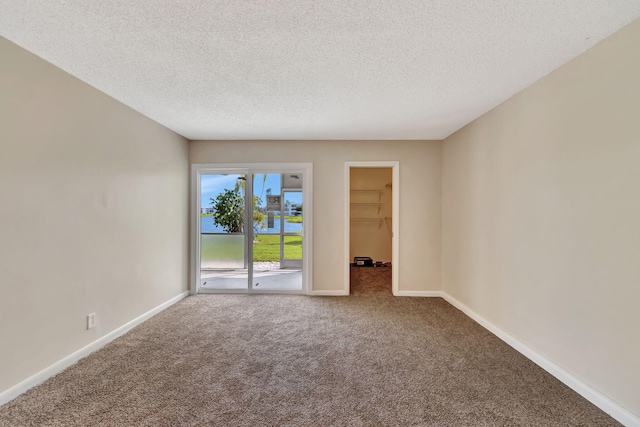 carpeted spare room featuring a textured ceiling