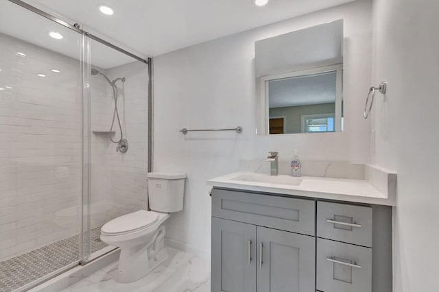 bathroom with vanity, a shower with shower door, and toilet