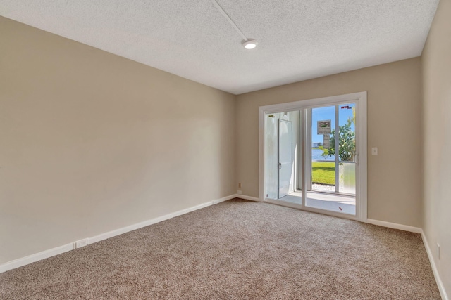 carpeted spare room featuring a textured ceiling