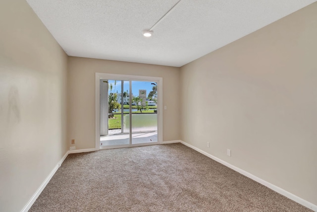 carpeted spare room featuring a textured ceiling